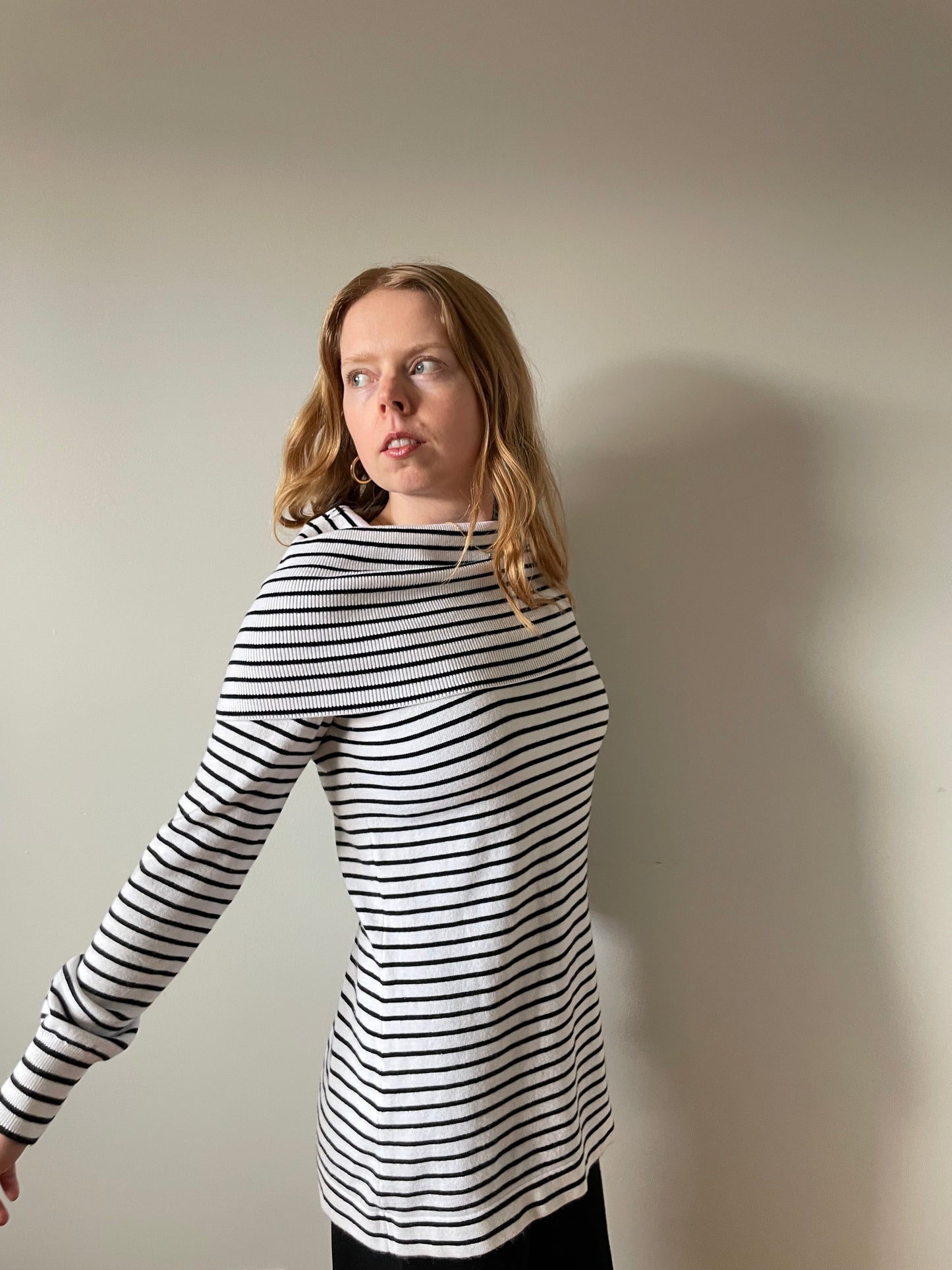 Person wearing a black and white striped outfit against a plain background