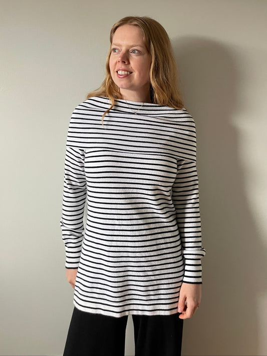 Person wearing a black and white striped shirt against a plain background